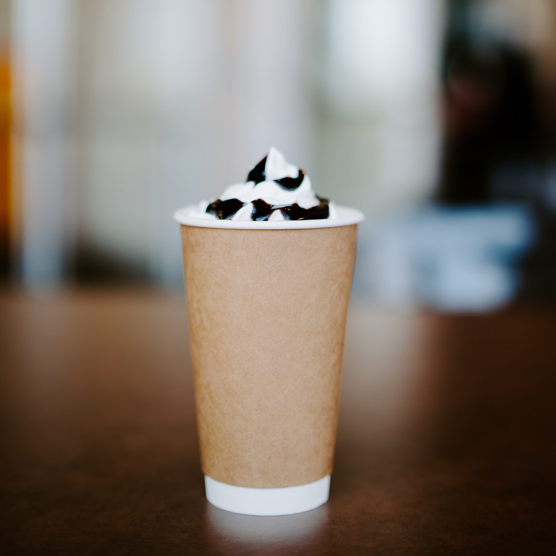 A hot drink topped with whipped cream and chocolate