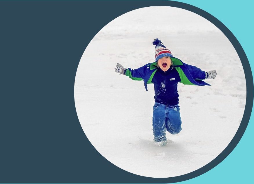 A child playing in the snow in a winter coat